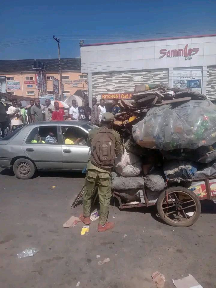 Young man in NYSC uniform spotted pushing heavily loaded truck in Port Harcourt 